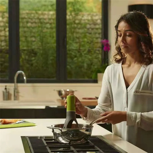 Automatic pot stirrer mixing food in a pan during hands-free home cooking